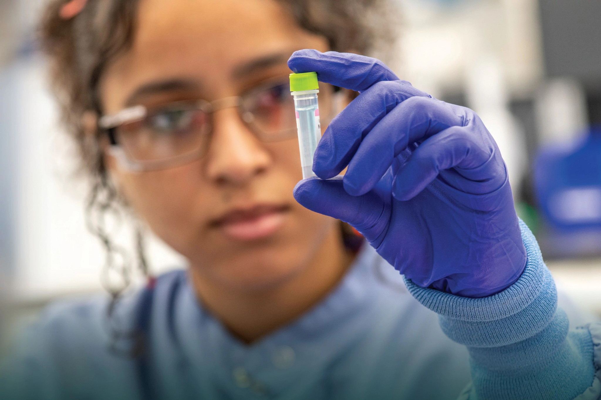 Cover of the 2025 Corporate Citizenship report showing a scientist wearing gloves and holding a vial.