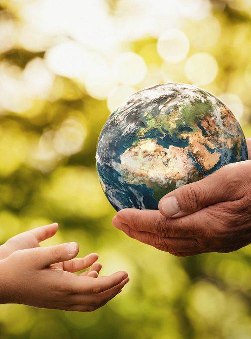 Conceptual image of an older person handing the earth to a younger person.