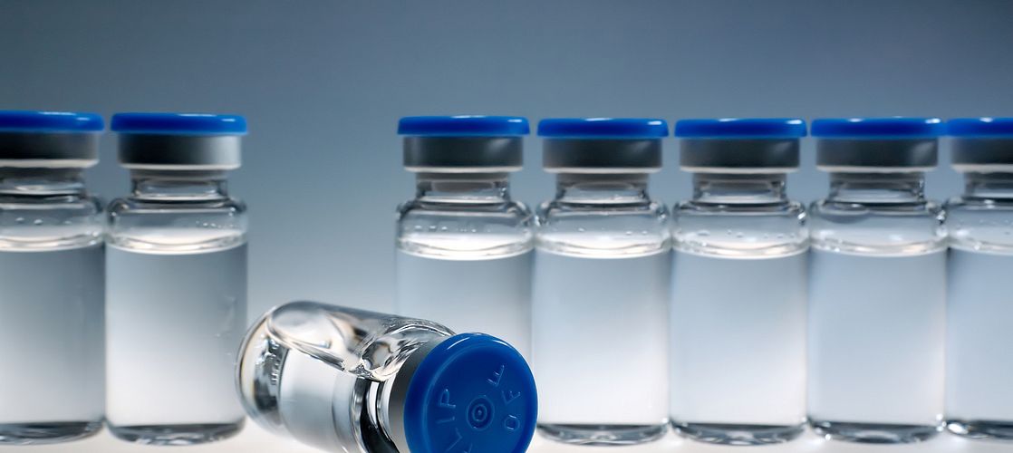 a row of little medication bottles with blue caps