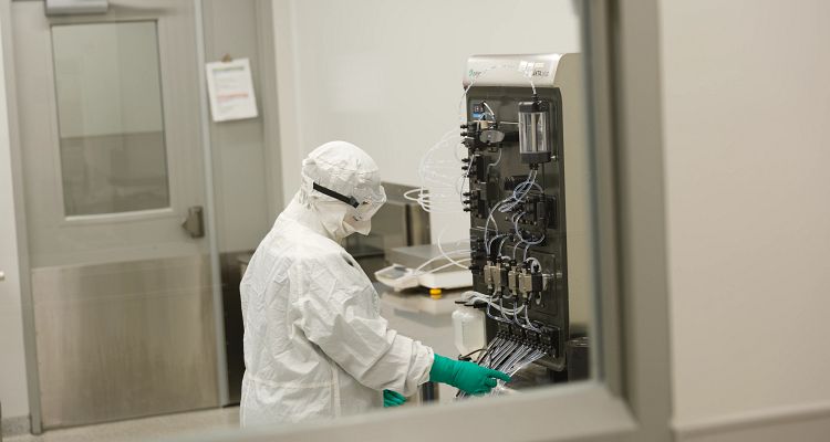 Scientist working in a lab wearing full PPE.