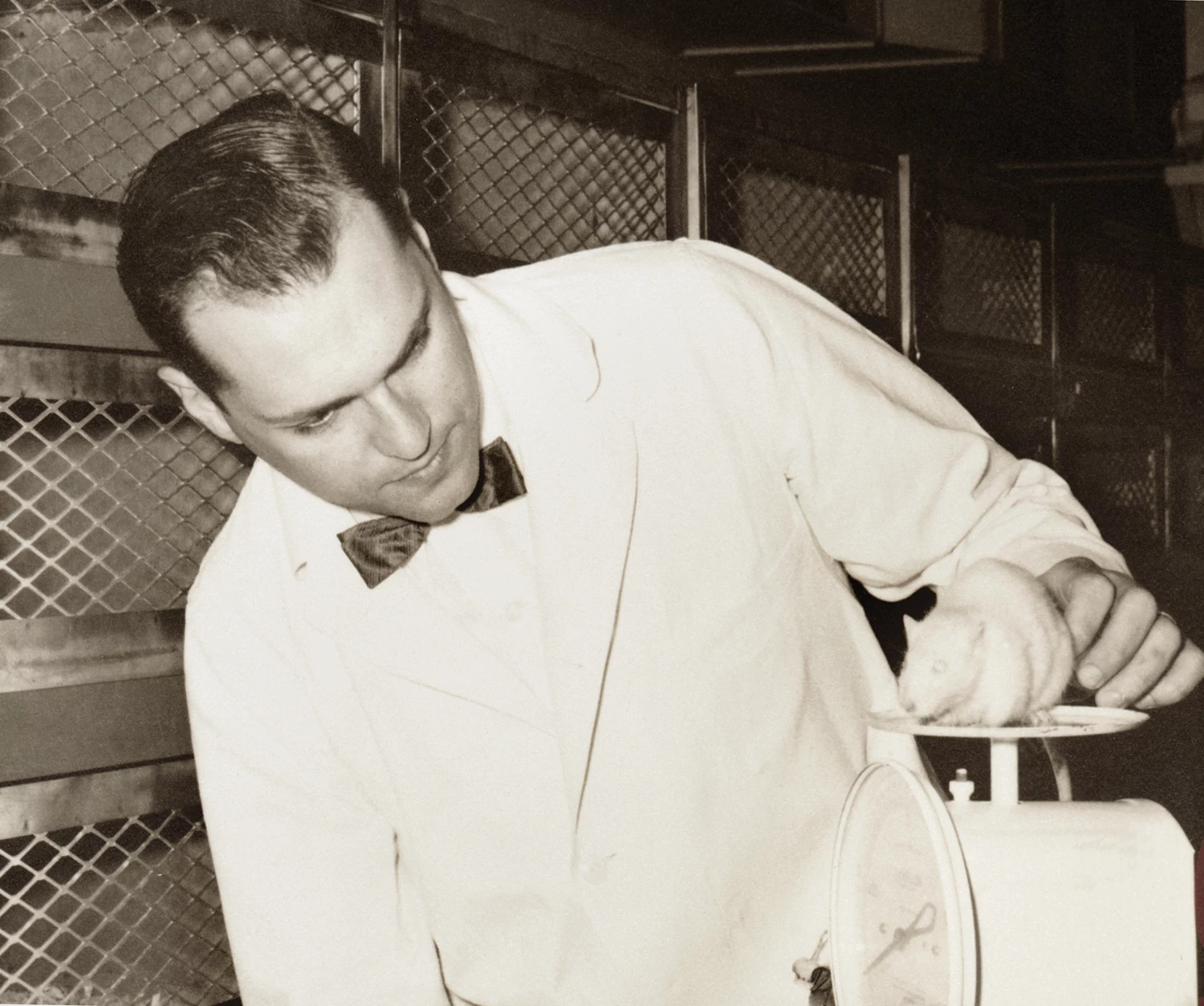 Photo of Henry Foster with a white mouse on a scale