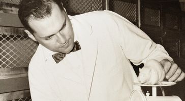 Photo of Henry Foster with a white mouse on a scale