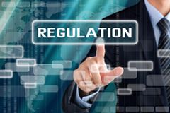 Businessman hand touching REGULATION sign on virtual screen