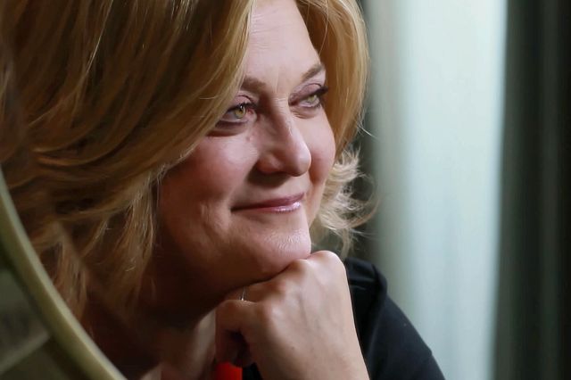 Photo of a woman named Ginger with light hair and a slight smile, looking away from the camera.