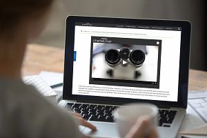 Image of person looking at resources on a computer with a cup of coffee. Charles River has many resources for Electrophysiology to aid your research.