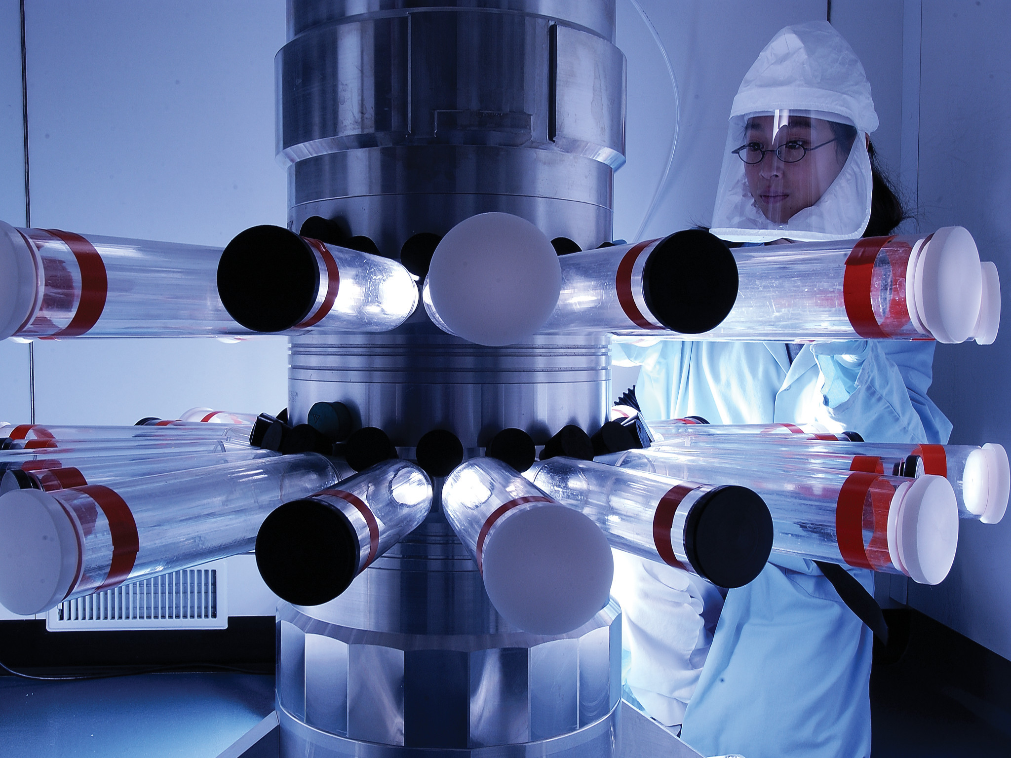 Scientist in lab where protective gear working with vials