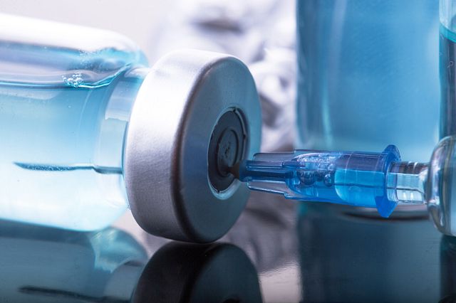 Photo of syringe in vaccine bottle.