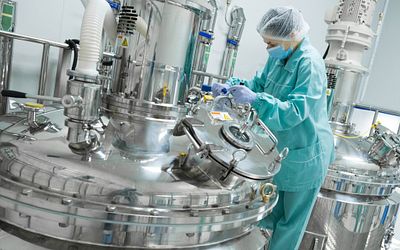 Pharmaceutical technician in sterile environment at pharmacy industry.