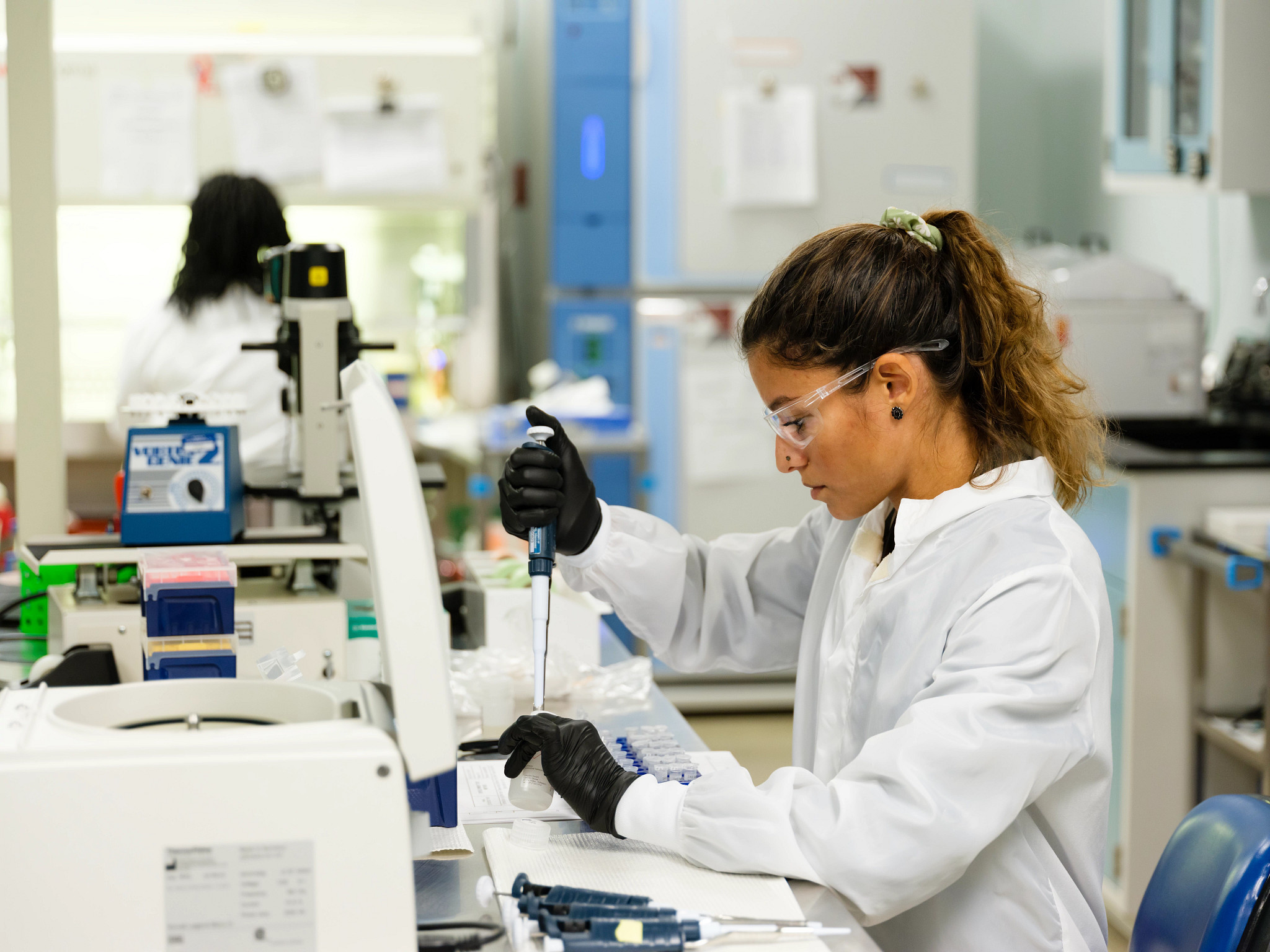 as part of the iPSC manufacturing process, a lab worker is using a dropper to fill a bottle