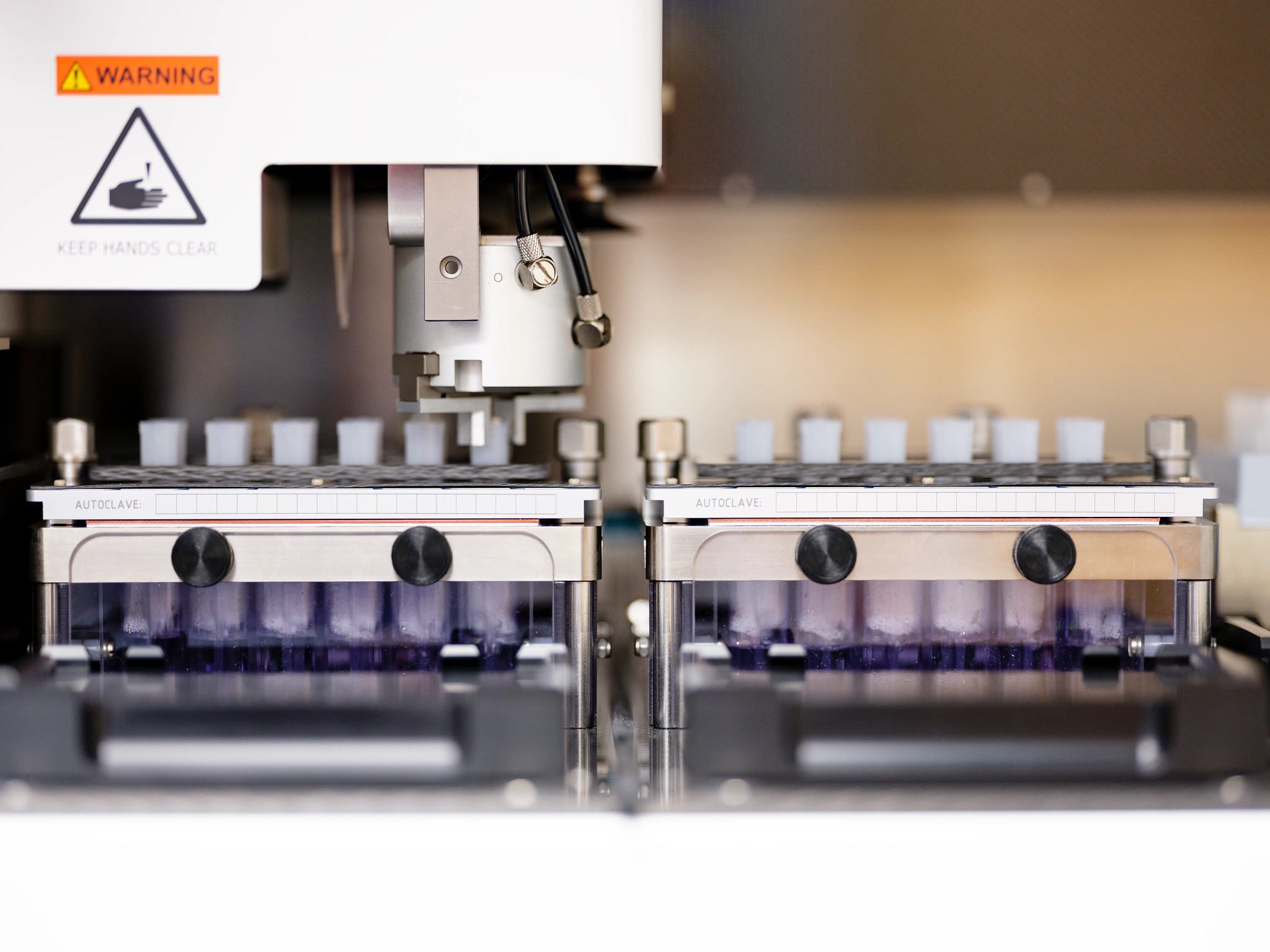 Scientist in a lab coat looking through a microscope.