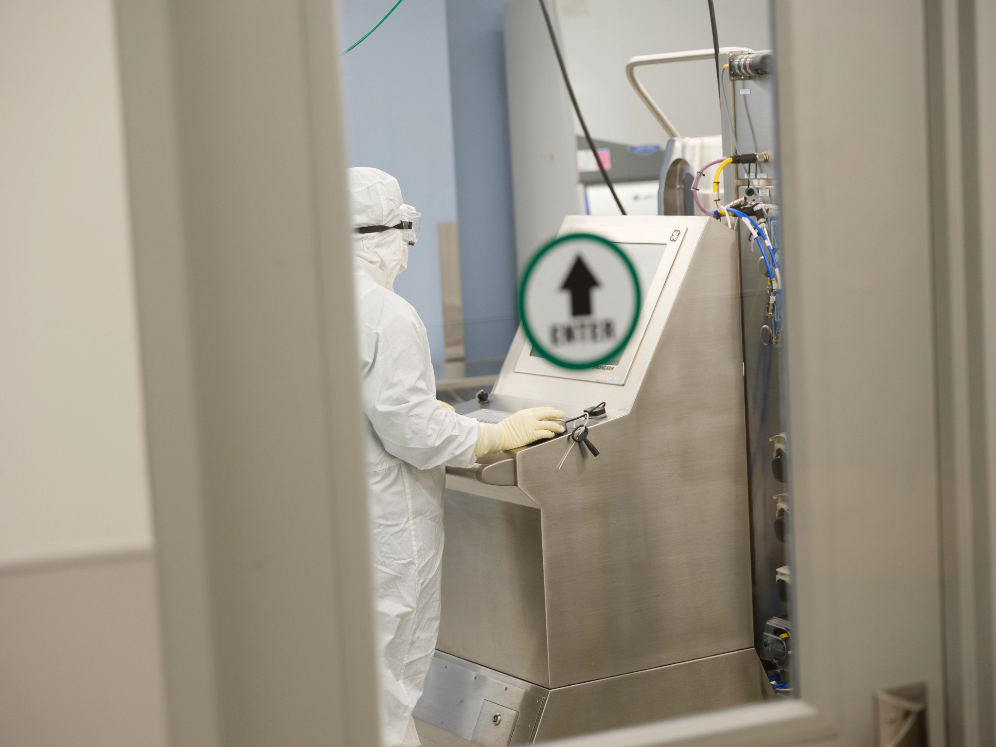 Scientist in PPE working at computer in lab