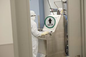 Scientist in PPE working at computer in lab