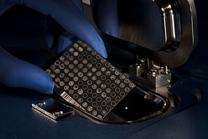 A scientist adding a plate reader to make a MALDI-TOF MS system work.