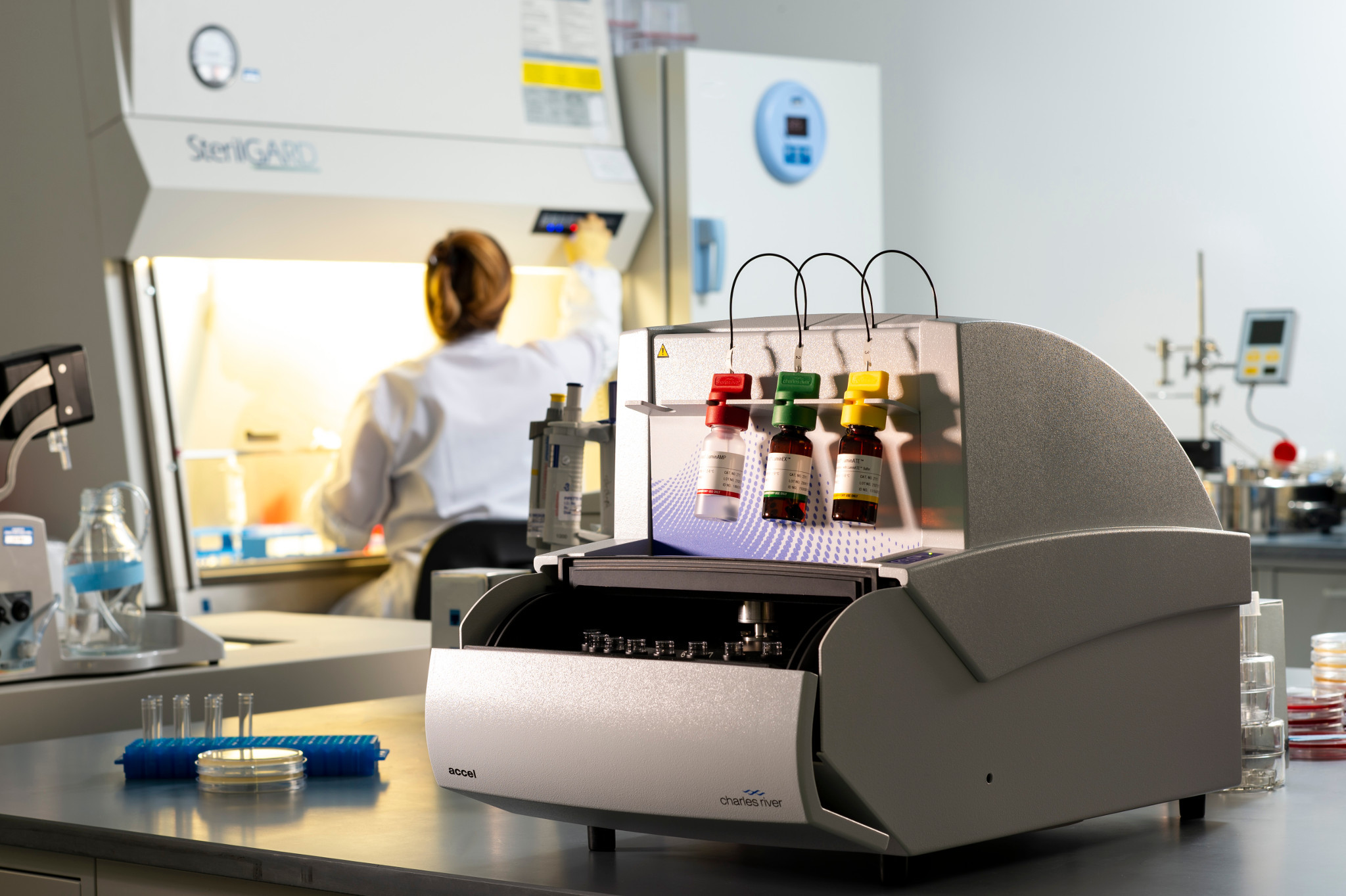 Scientist working in a lab with a Celsis Accel on the bench