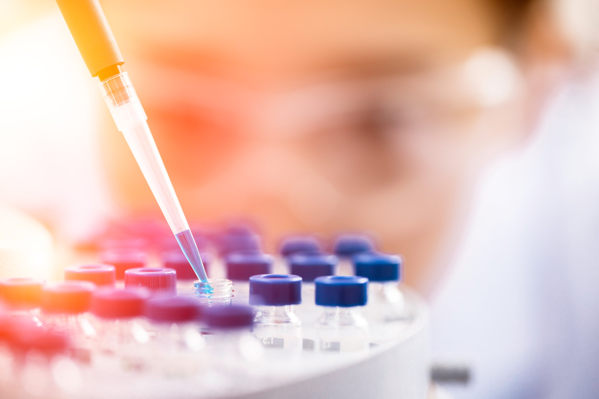 Close up shot of female scientist working with dropper and vials