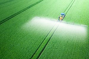 tractor with attachment to apply fertilizer to large green field