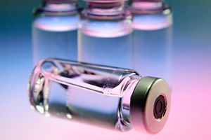 uncapped medicine bottle with pink and blue faded background