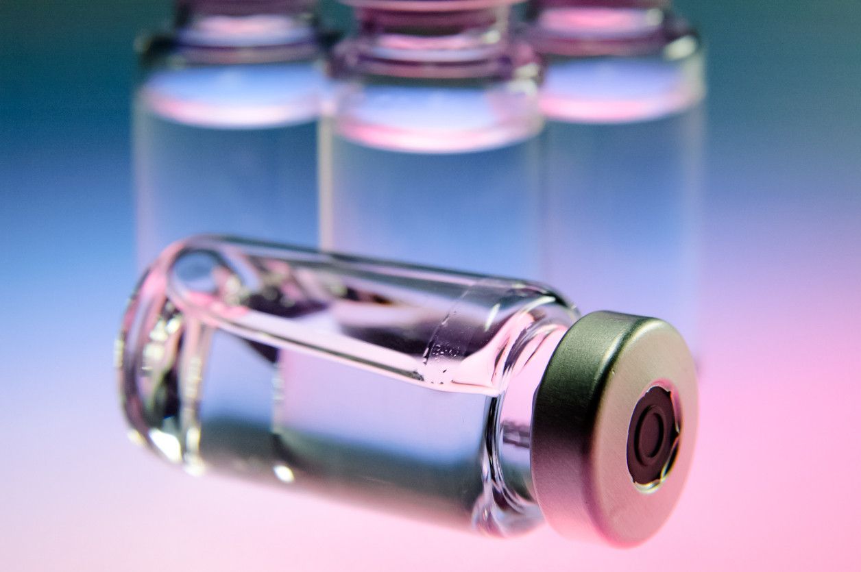 uncapped medicine bottle with pink and blue faded background