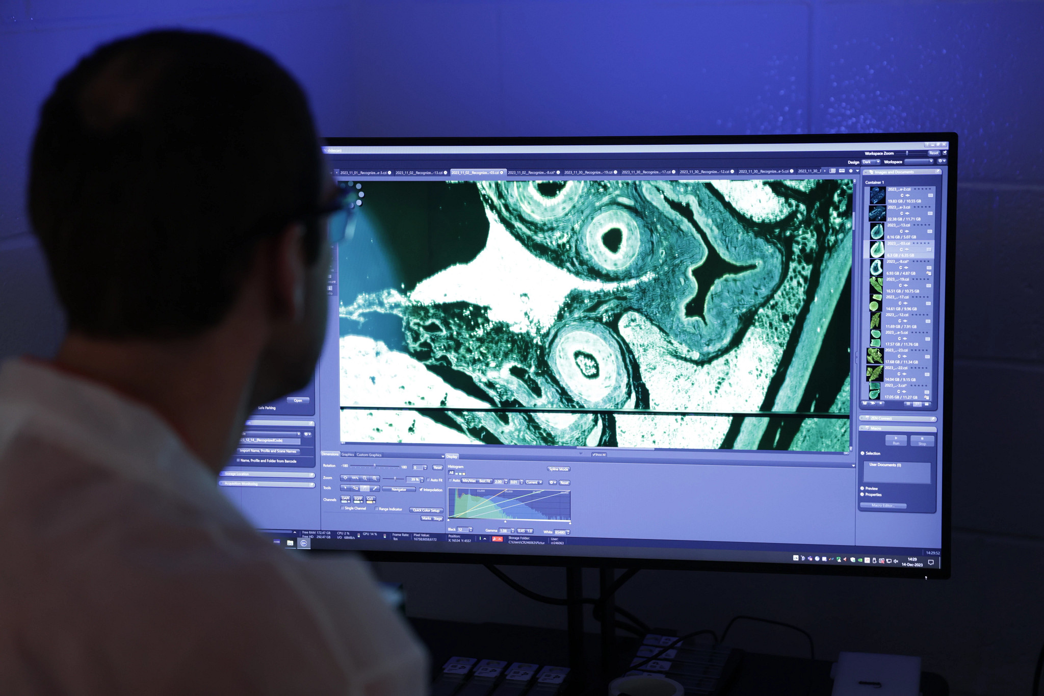 Scientist looking at digital pathology slide at integrated toxicology site in Kansas over a monitor.