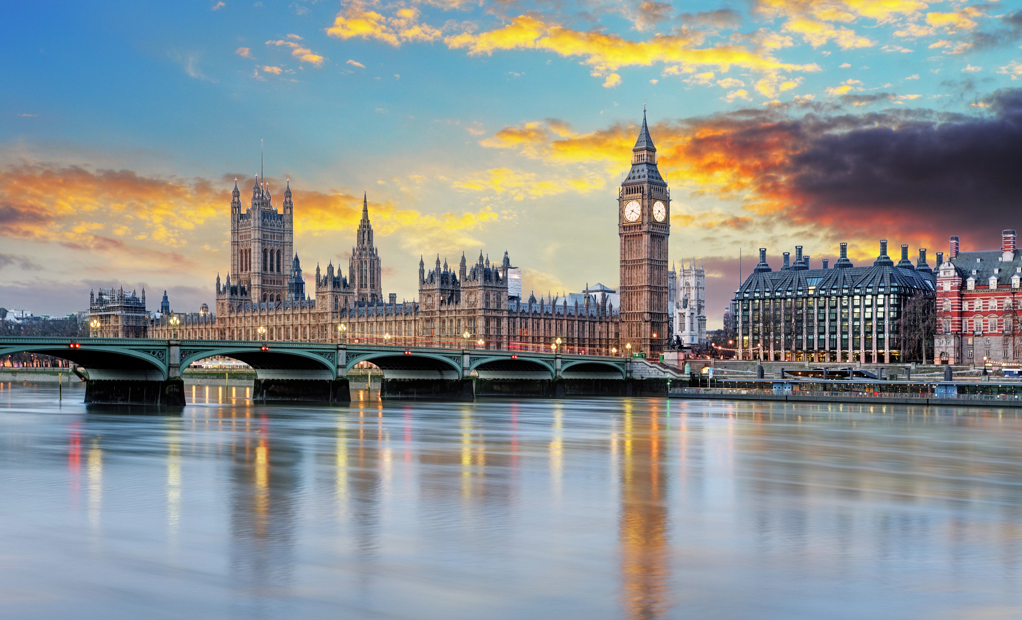 Photo of the London Parliament building and Big Ben with a sunset in the background.