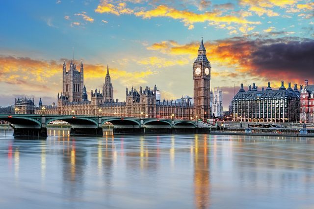 Photo of the London Parliament building and Big Ben with a sunset in the background.