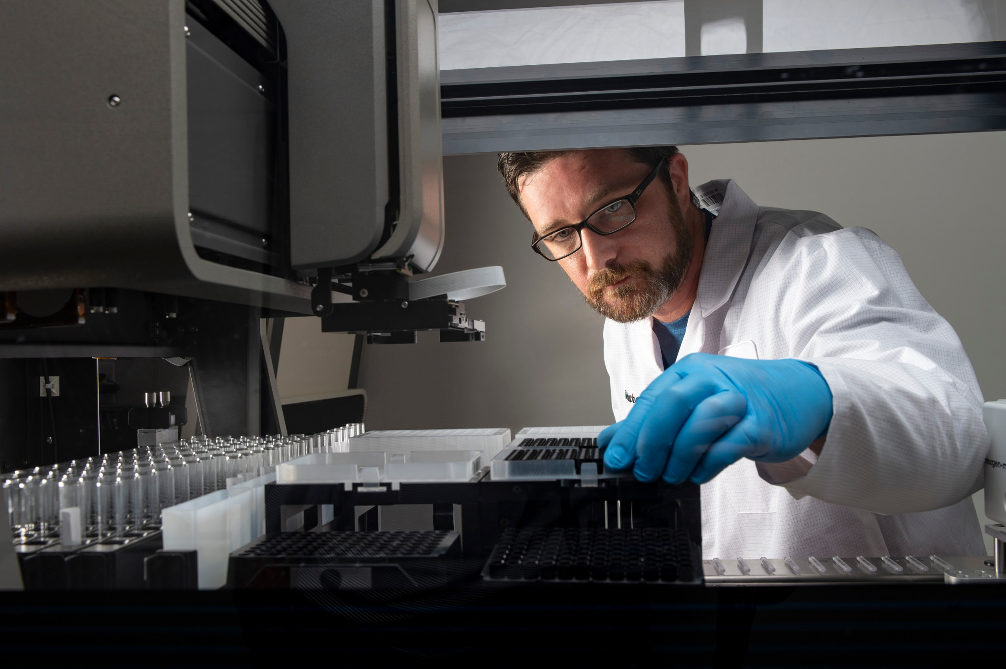 Technicien examinant des échantillons dans une machine de test automatisé des endotoxines bactériennes.