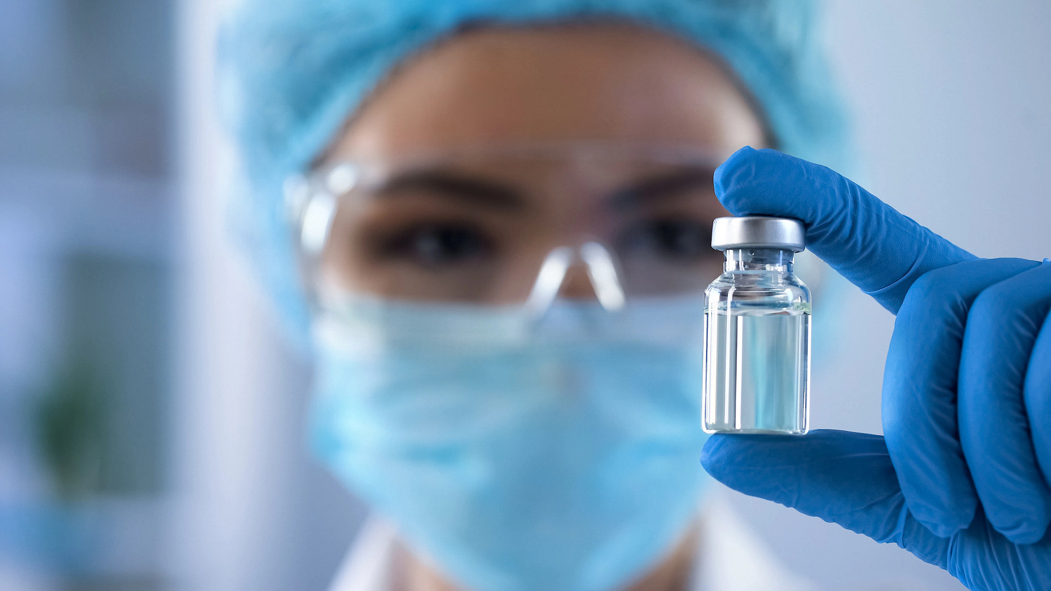 Charles River scientist holding a vial of vaccine in a lab performing vaccine challenge studies