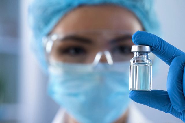 Charles River 科学家在实验室拿着一瓶疫苗进行疫苗挑战研究