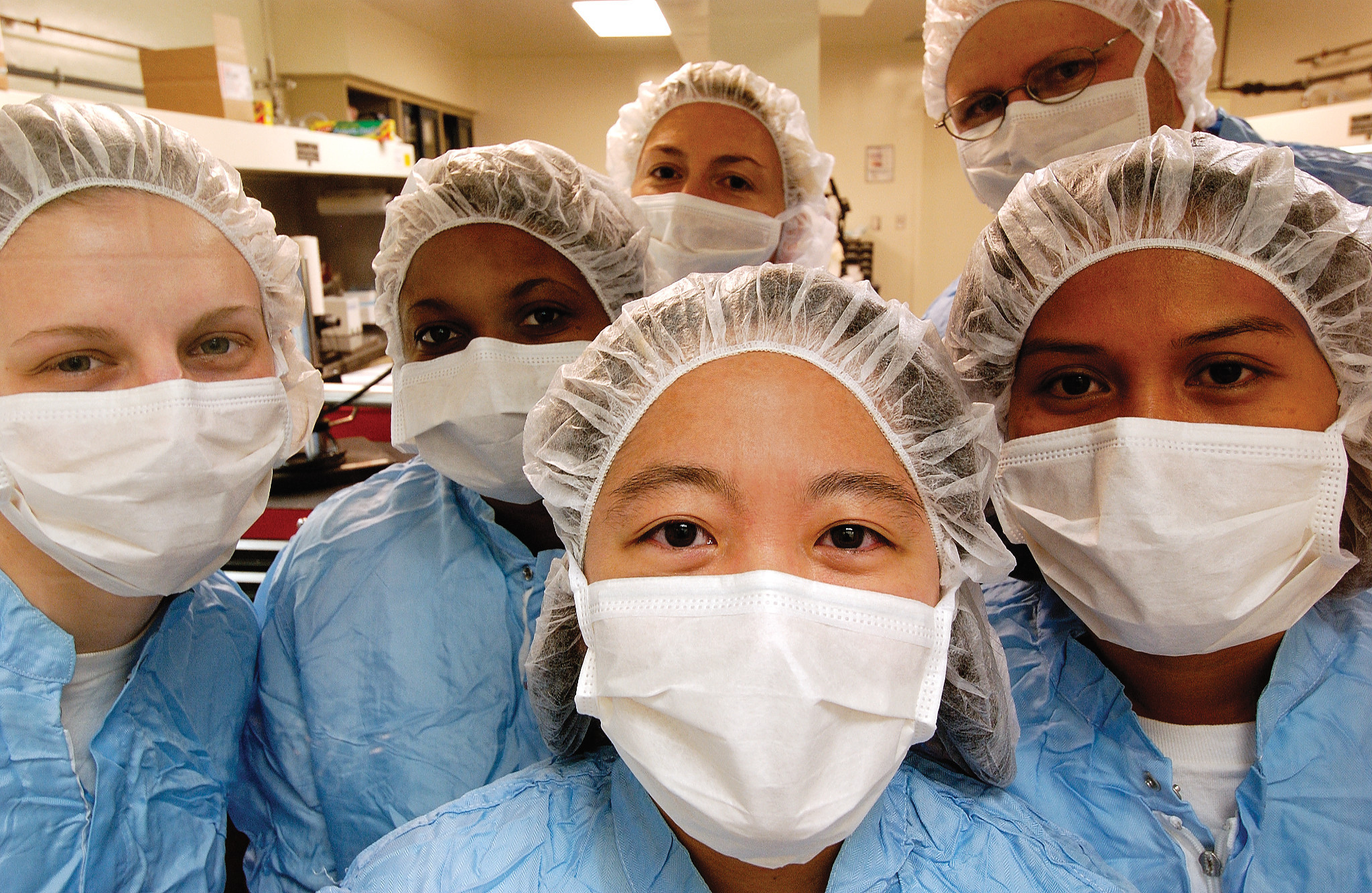 group of lab techs in gowns and gloves