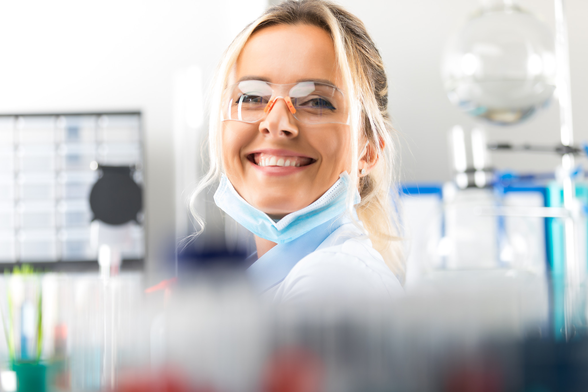 woman scientist with protective eyeglasses in the scientific chemical laboratory