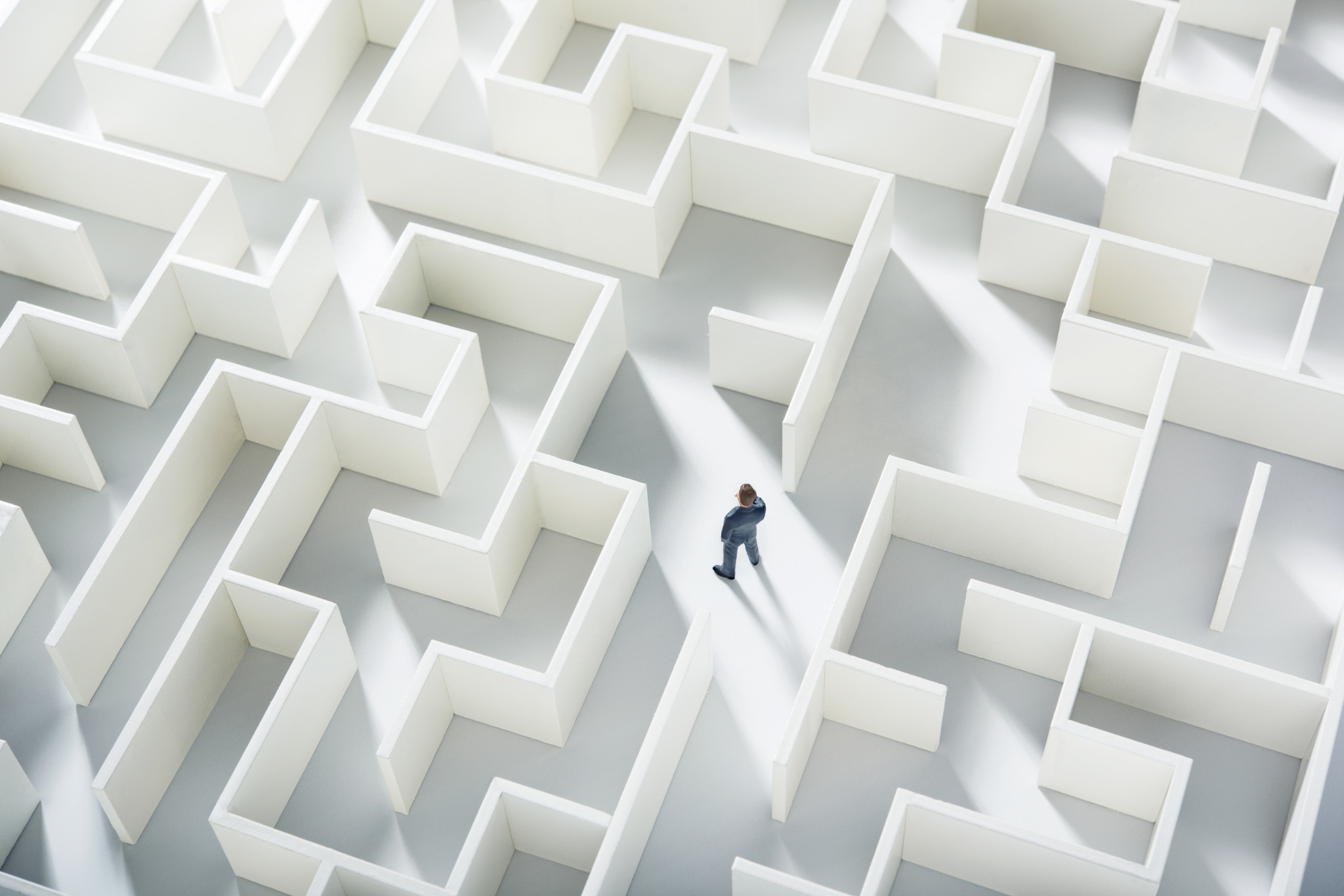 A businessman navigating through a maze. Top view.