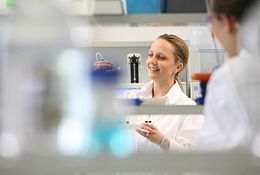 Technician performing assay for host cell proteins (HCPs) in a lab.